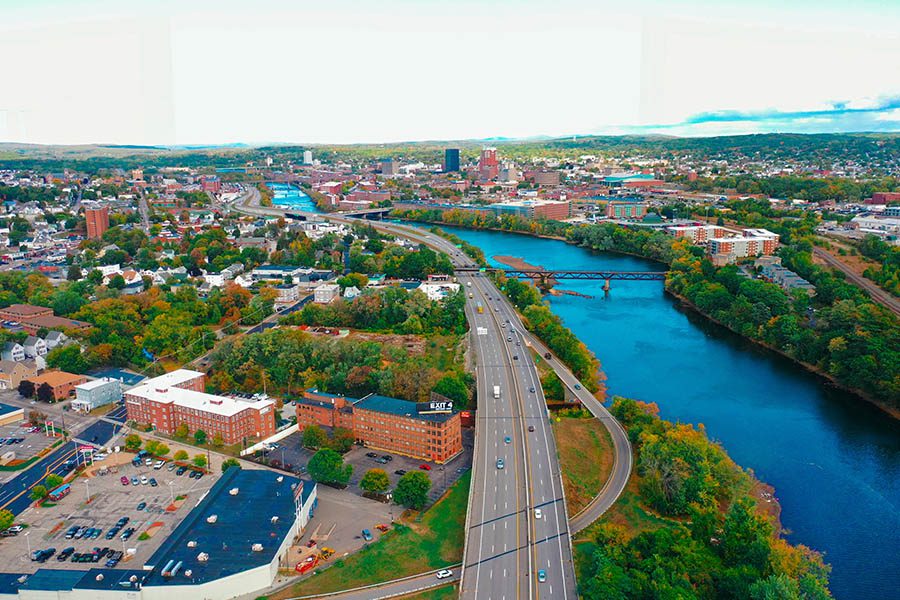 Bedford, NH Insurance - Aerial View of Bedford, NH in the Fall Above River and Highway